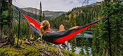 woman sitting in hammock looking out on forest