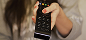 image of woman's hand holding a remote