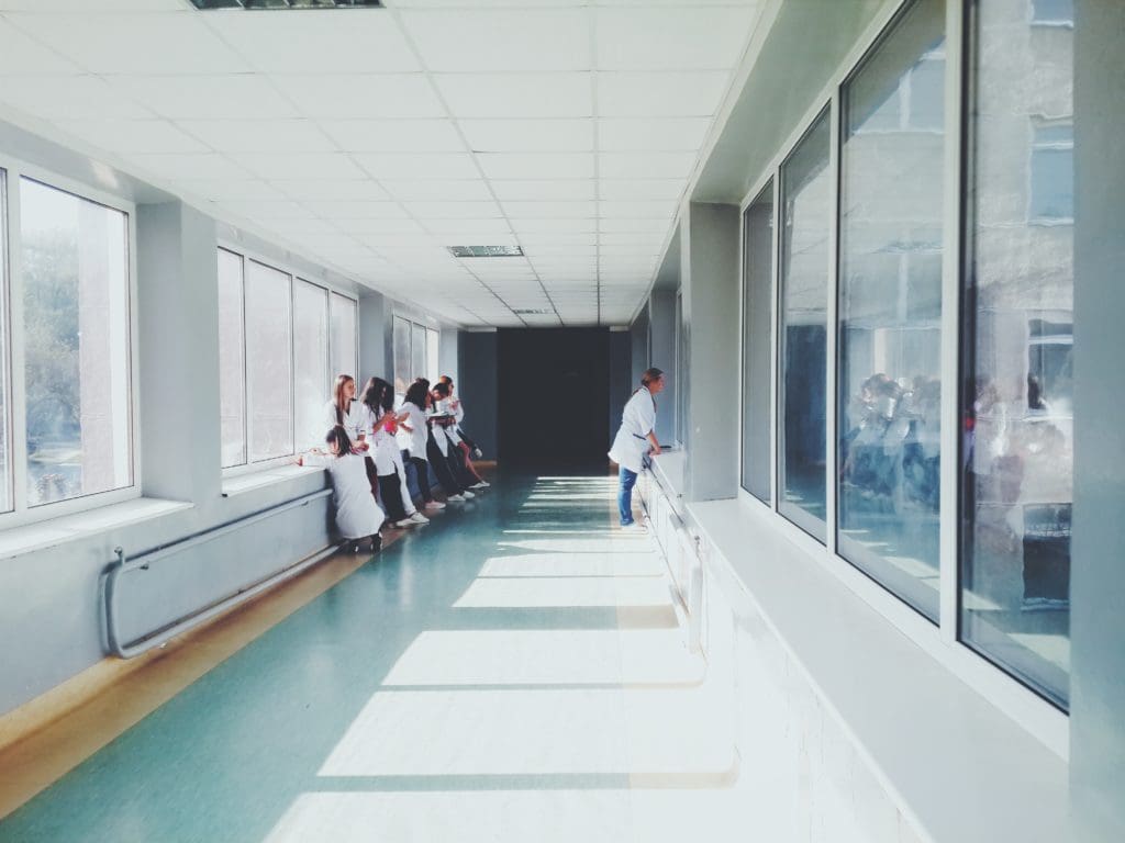 image of nurses hanging out in hospital hall for blog post on how to avoid hospital drama as a travel nurse