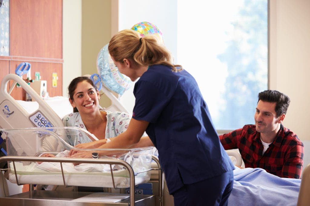 A labor and delivery nurse attends to a baby. Delivery nurses are one of the best travel nursing specialties in 2019.